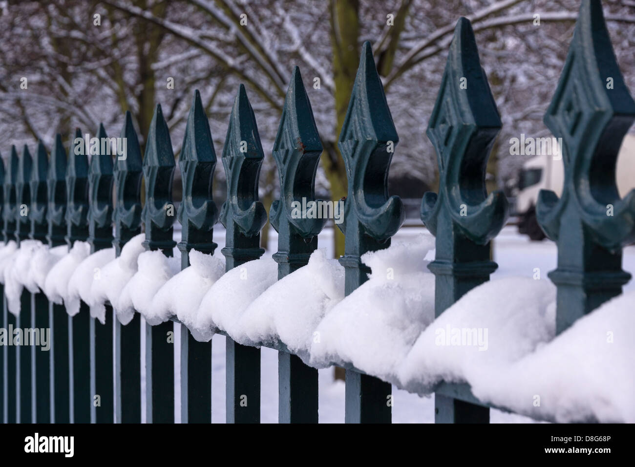 Snowy iron metal fence railings with spear shaped finials, UK Stock Photo