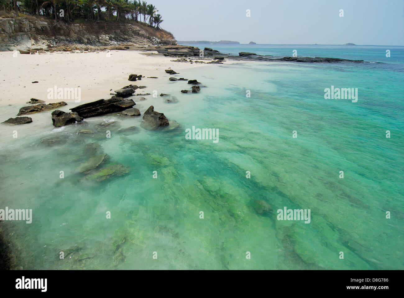 Rocky beach with clear waters and palm tree forest in Contadora island Stock Photo