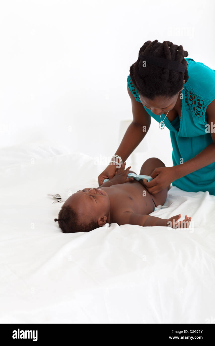 African American mother changing baby's diaper Stock Photo
