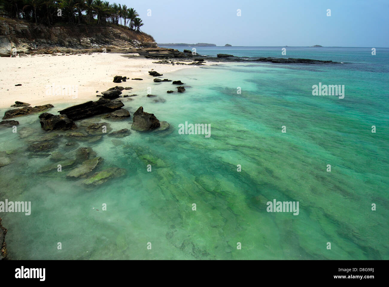 Rocky beach with clear waters and palm tree forest in Contadora island Stock Photo