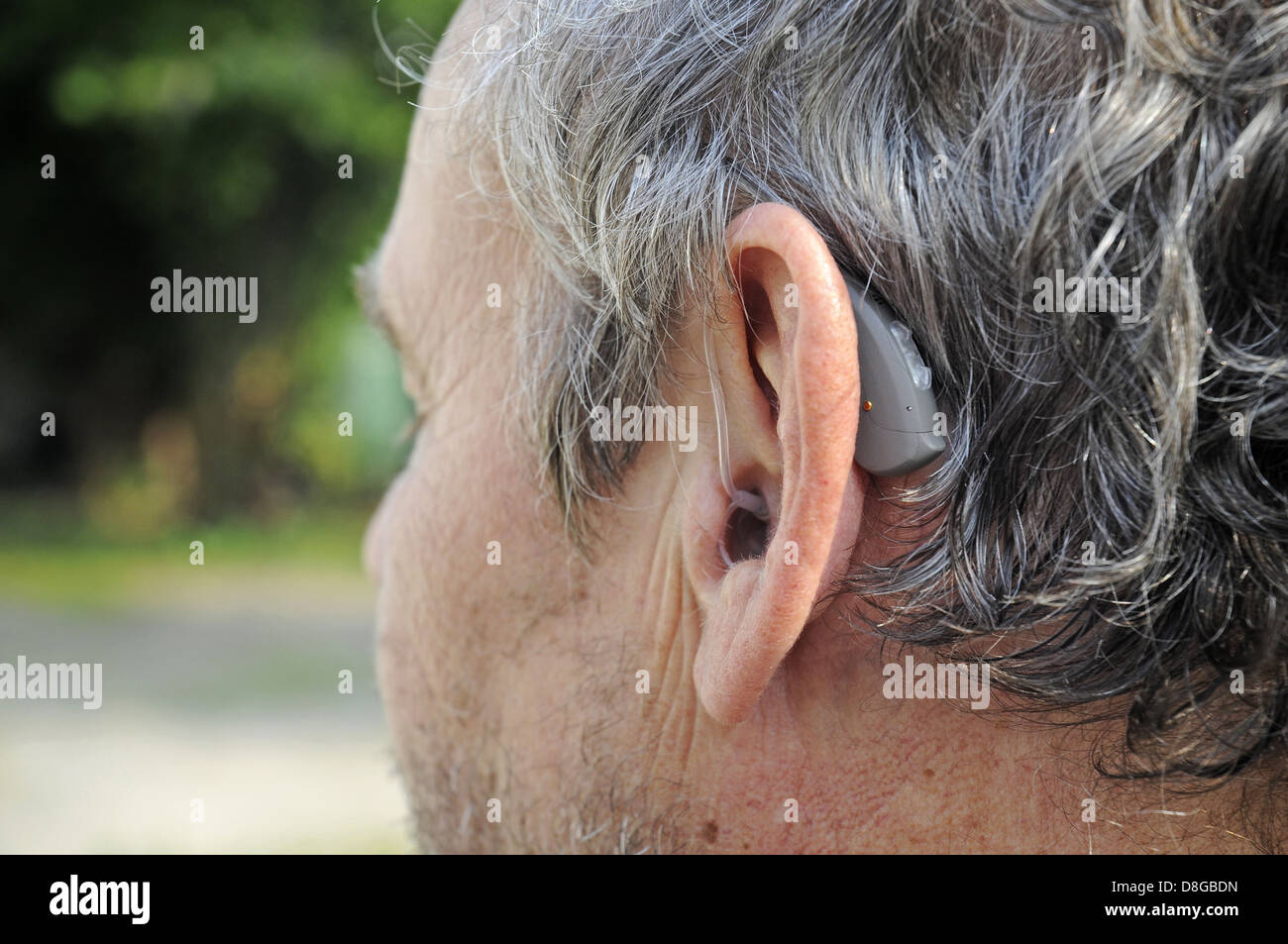 Hearing aid behind the ear of a man Stock Photo
