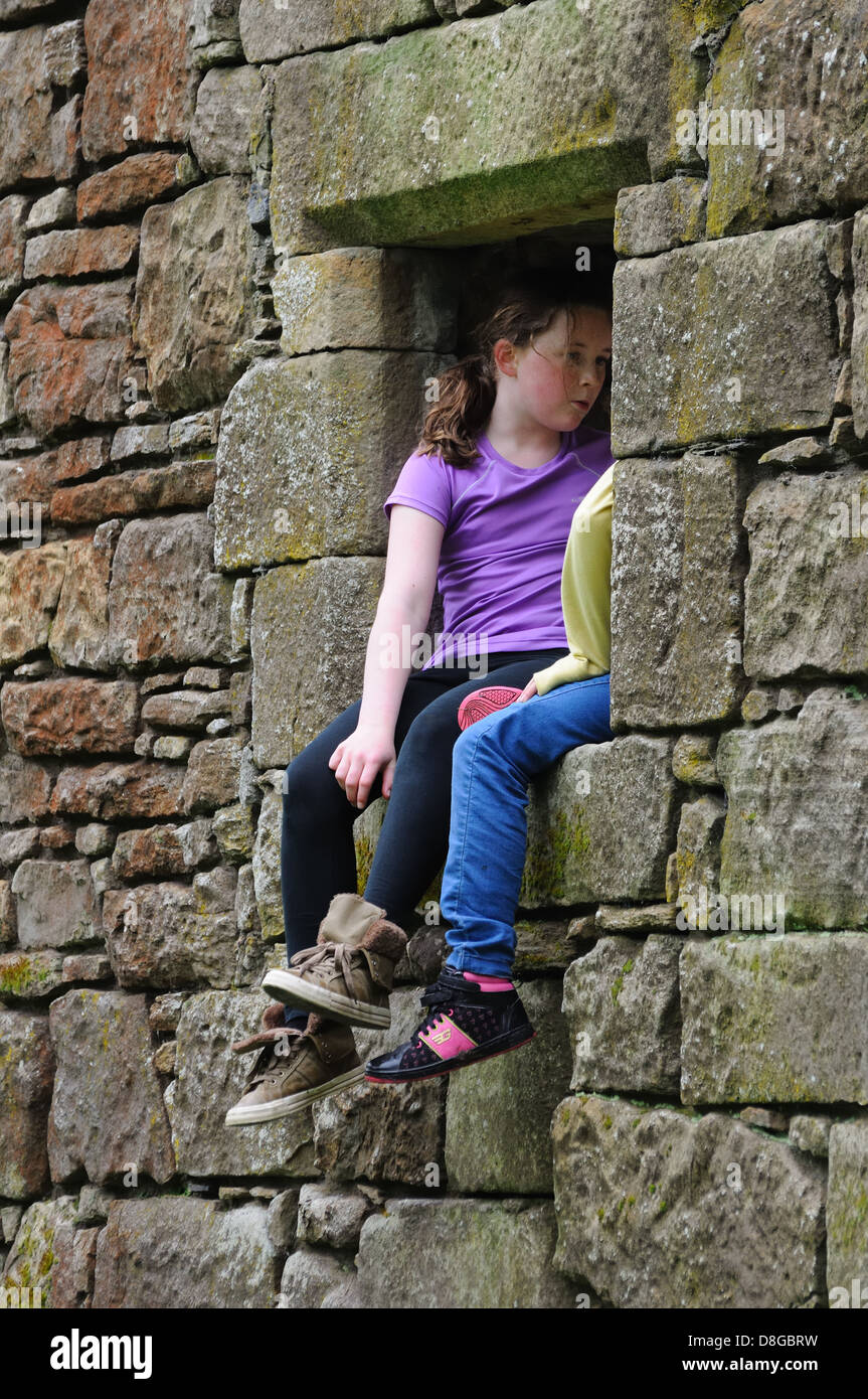 Two young girls playing in the ruins of an old church in Clyde Muirshiel Regional Park Stock Photo