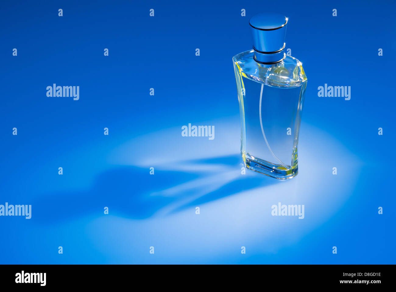 Perfume bottle on blue background Stock Photo - Alamy