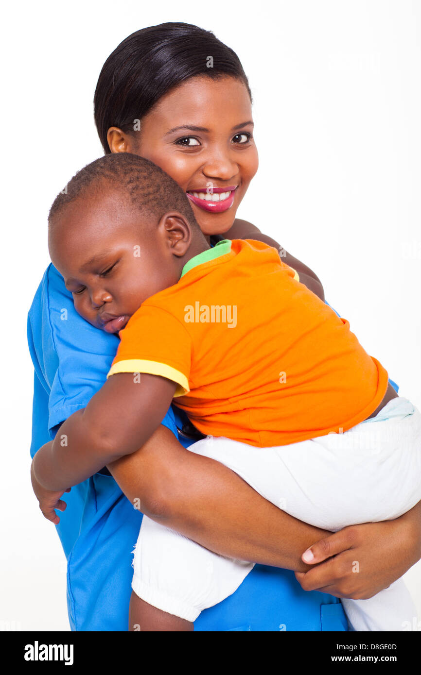 portrait of beautiful young African nurse carrying sleeping baby boy