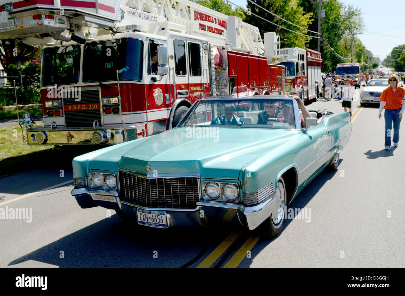 Vintage cars transport veterans of WWII though memorial day parade
