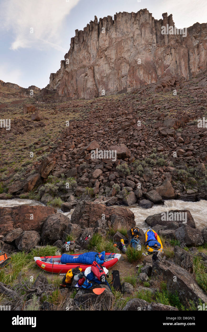 Kayakers sleeping in inflatable kayaks at a camp along the Jarbidge
