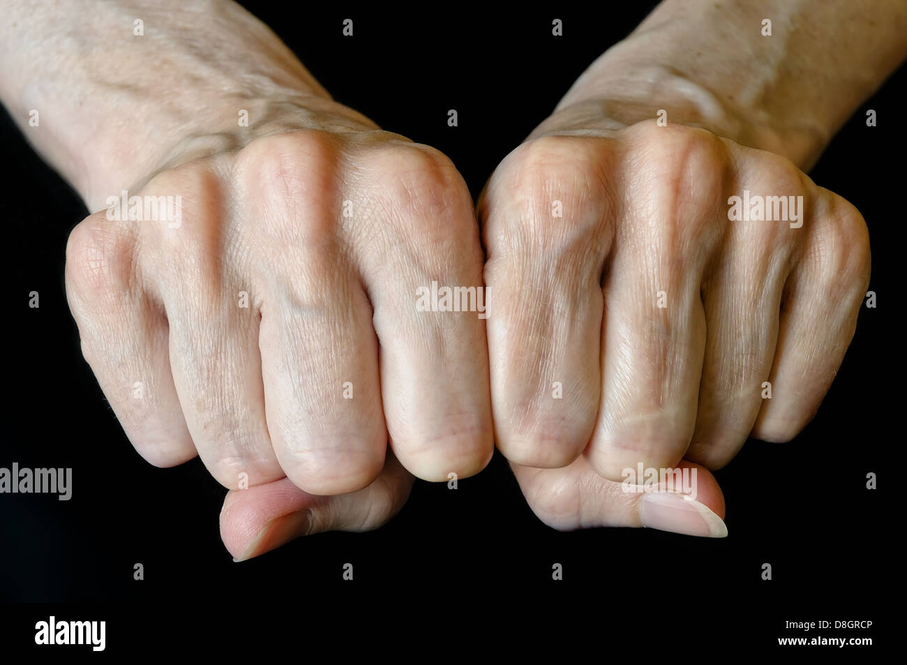 Senior woman showing fists on black background Stock Photo