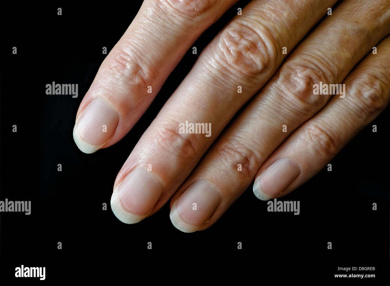 Nice senior woman's fingers on black background Stock Photo