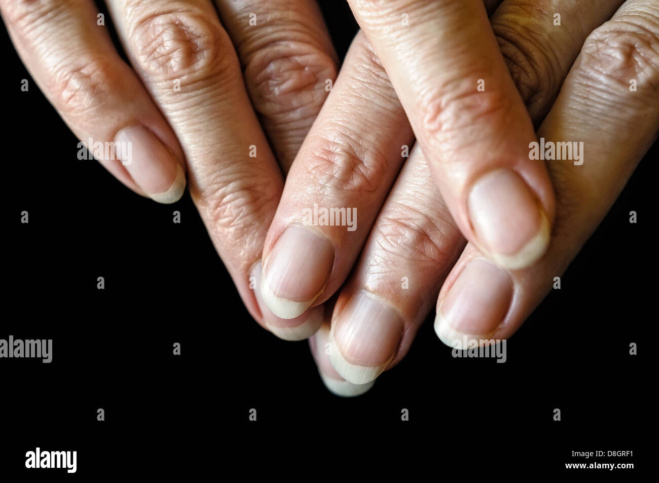 Nice senior woman's fingers on black background Stock Photo