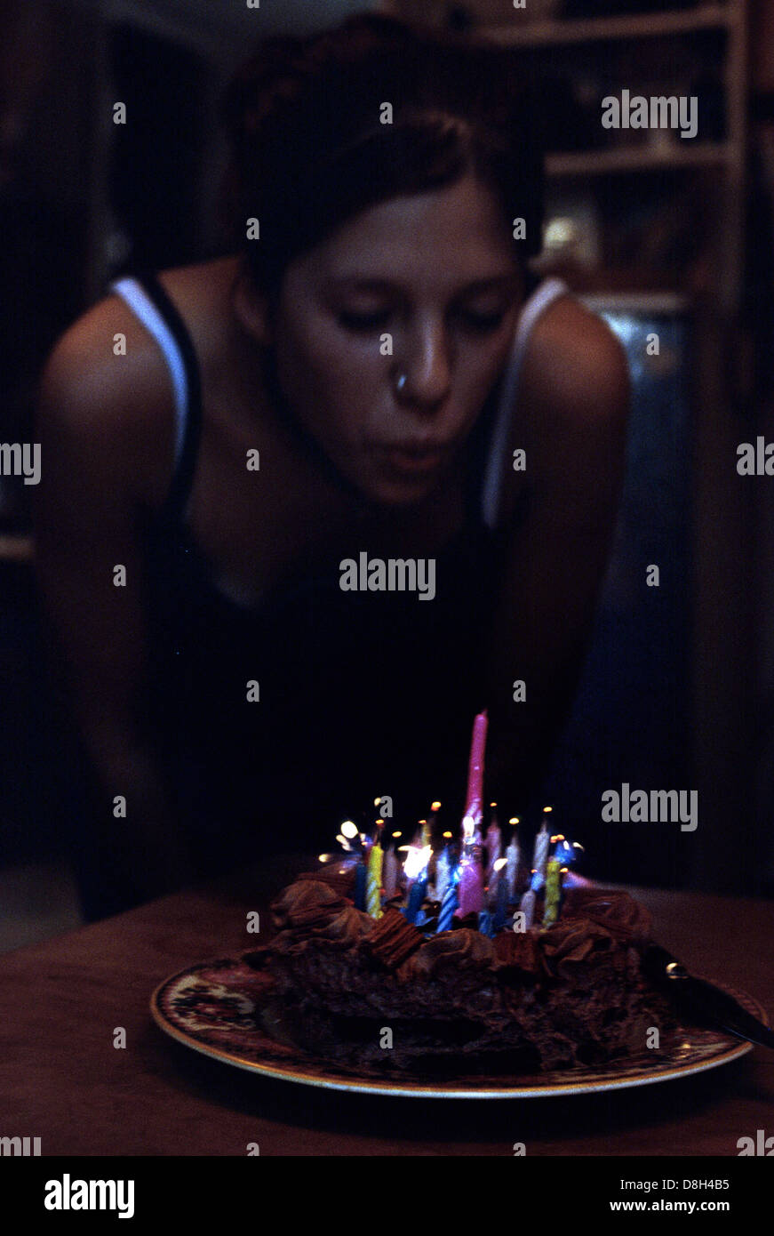 Birthday cake candles being blown out with no lights on Stock Photo Alamy