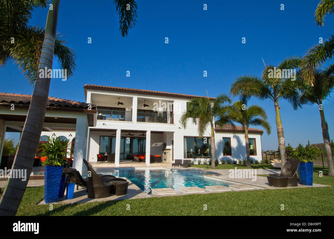 Luxury Home worth several million dollars pool with palm trees and blue sky Stock Photo