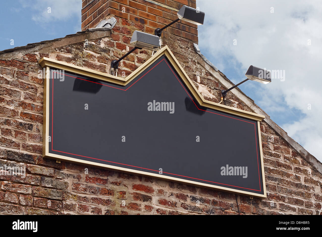 Traditional public house or tavern sign on side of old building blank for insertion of pub name Stock Photo
