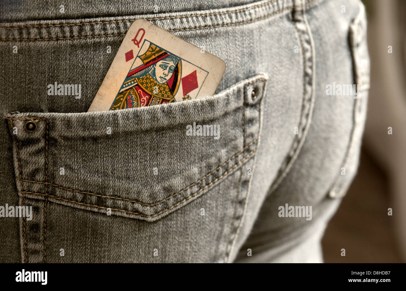 How to gamble Queen of diamonds playing card in a back pocket of a pair of jeans Stock Photo