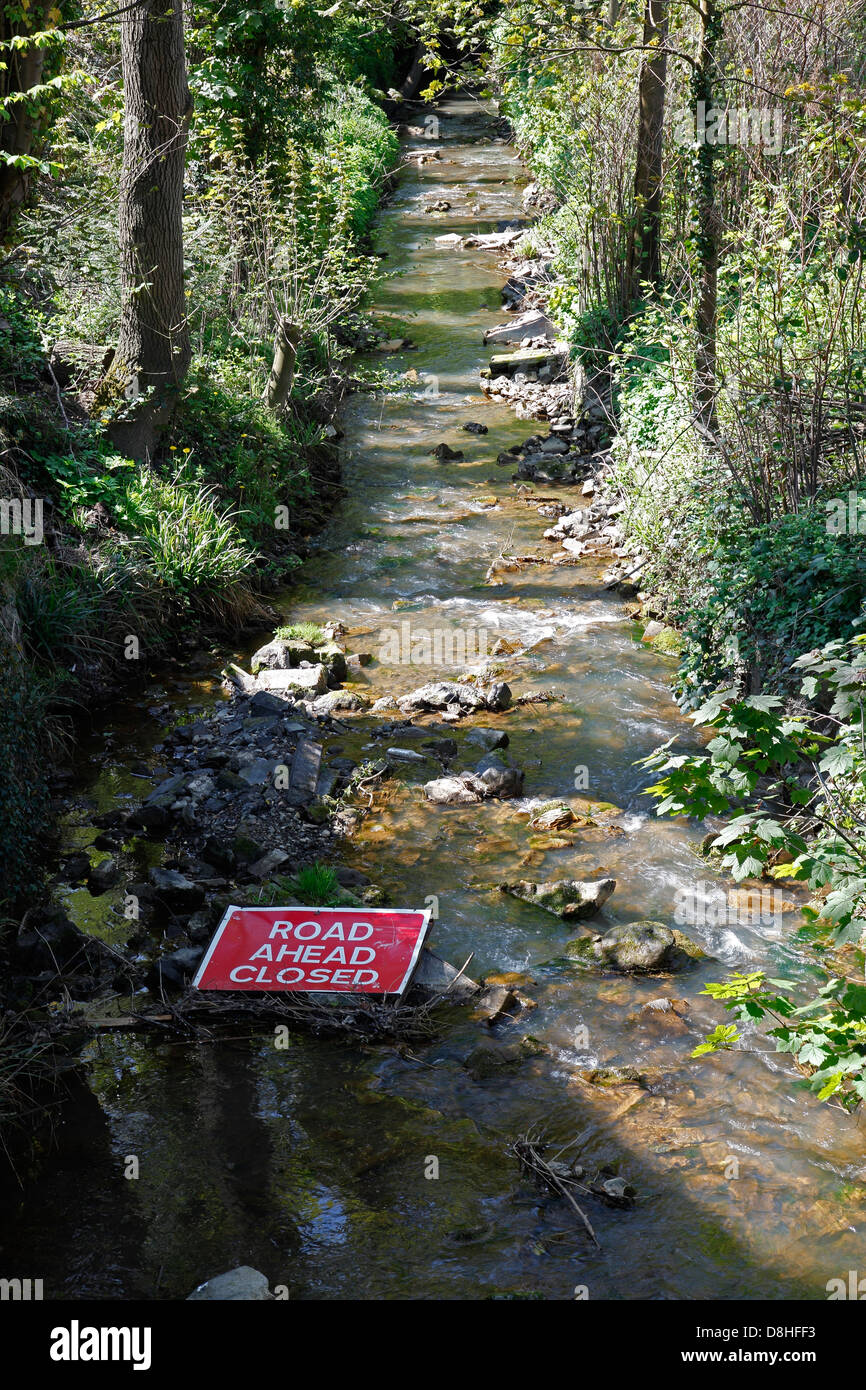 Road ahead closed sign in stream Stock Photo