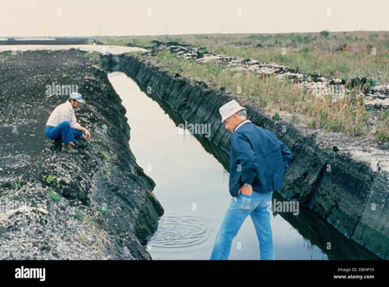 Workers are seen in a drainage channel, engaged in tasks related to ...