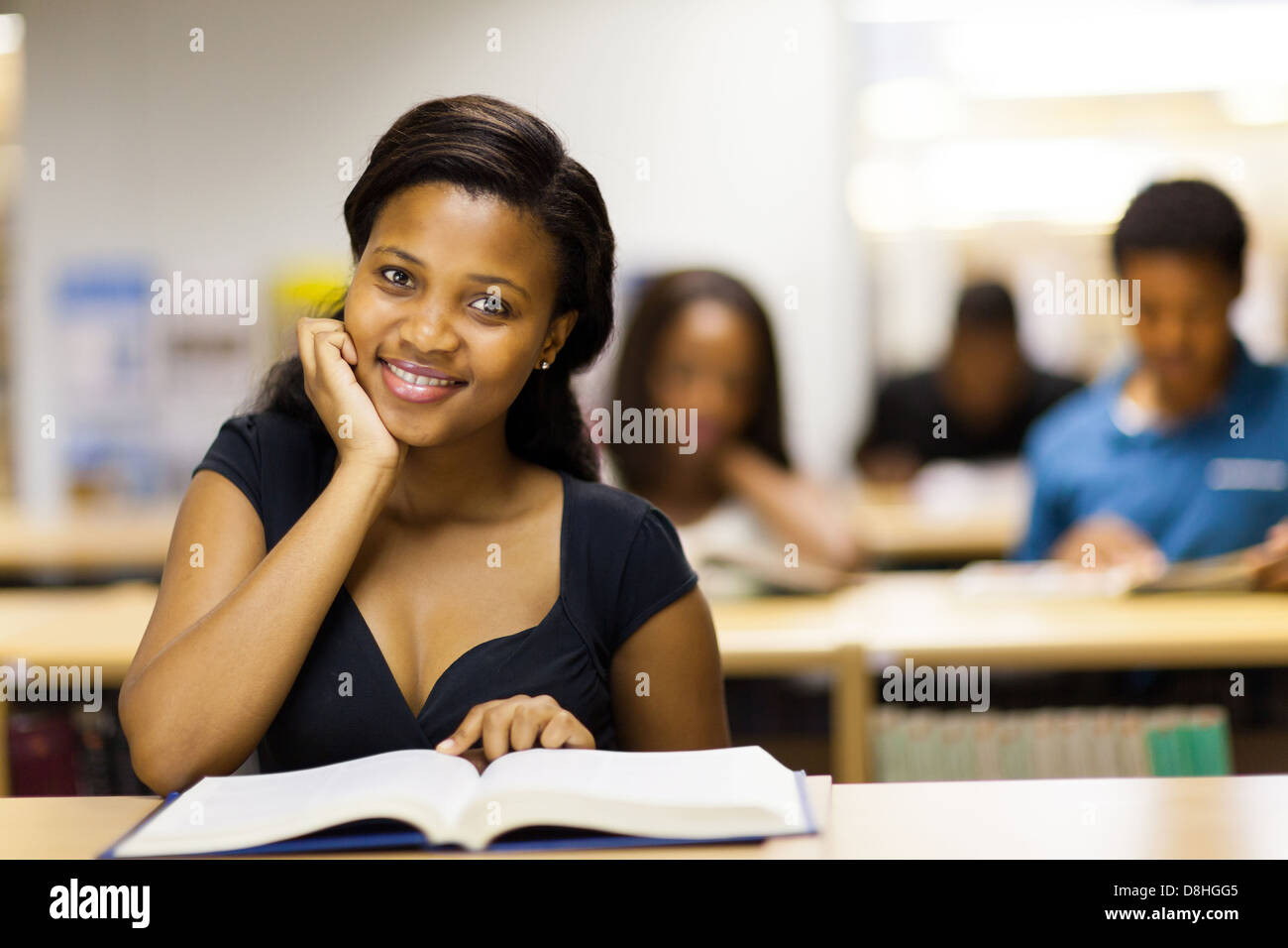 pretty african college student reading book in library Stock Photo