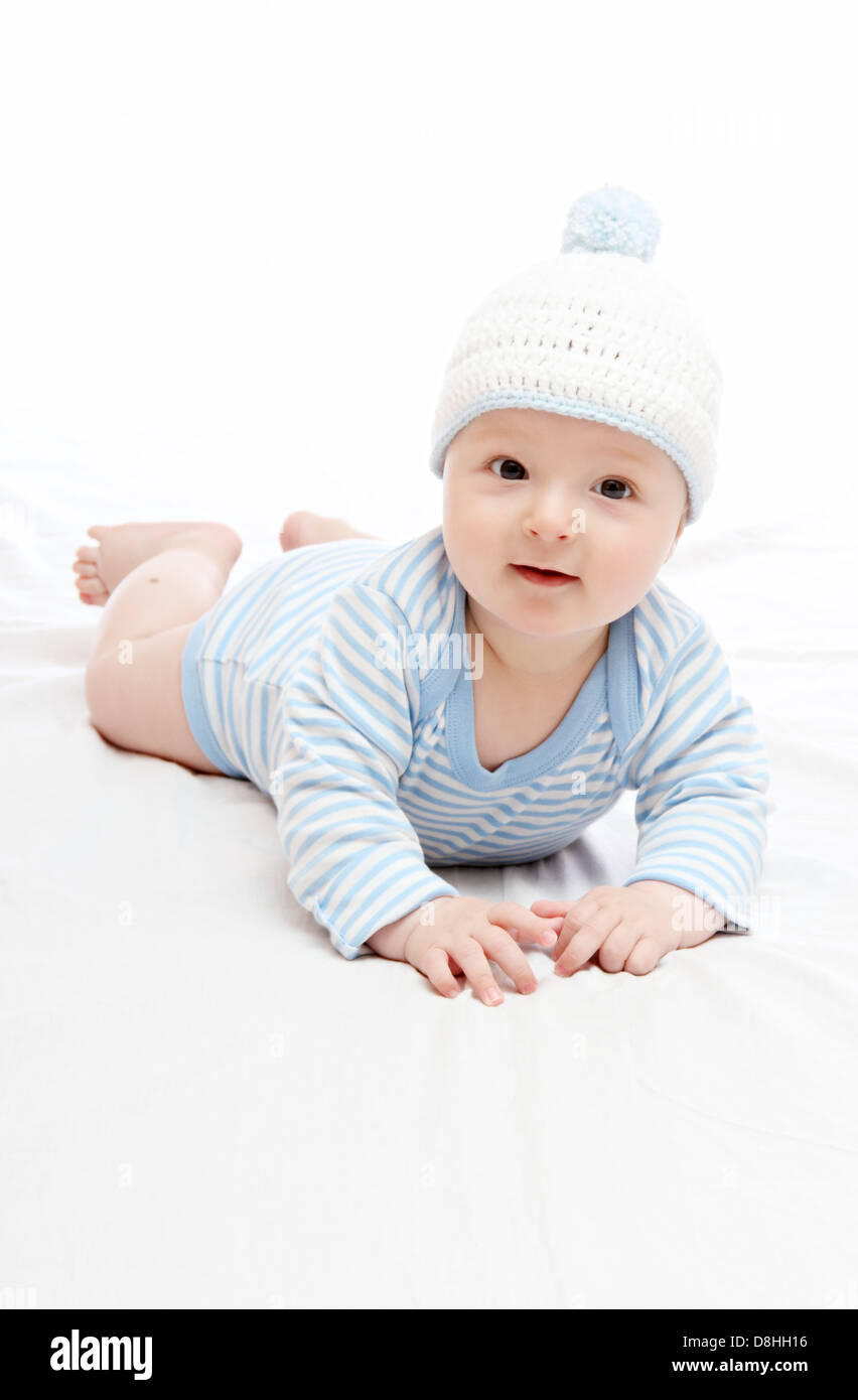 Beautiful baby boy in blue hat on the bed Stock Photo
