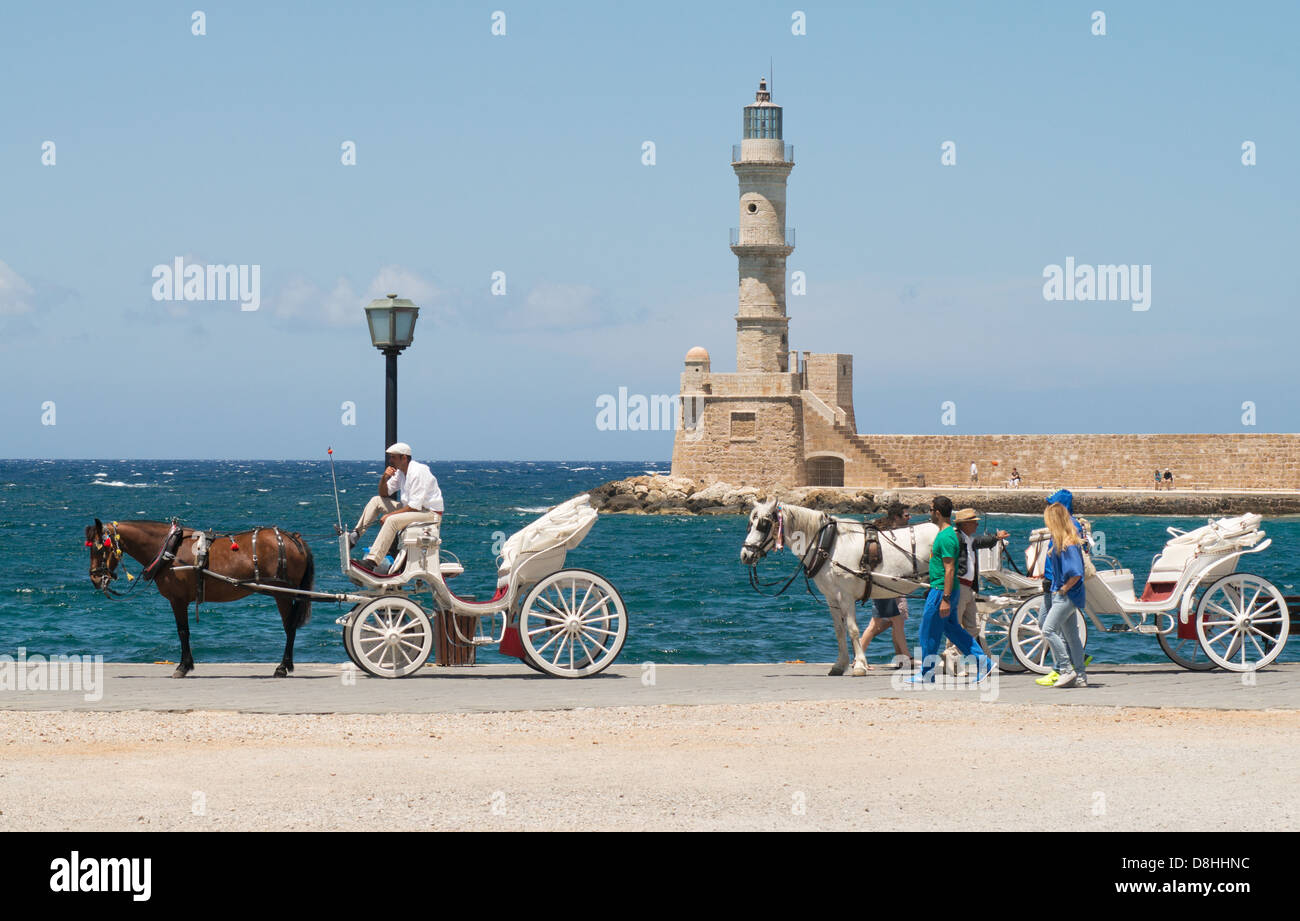 horses and carriages await tourists, Chania Venetian harbour, Crete Stock Photo