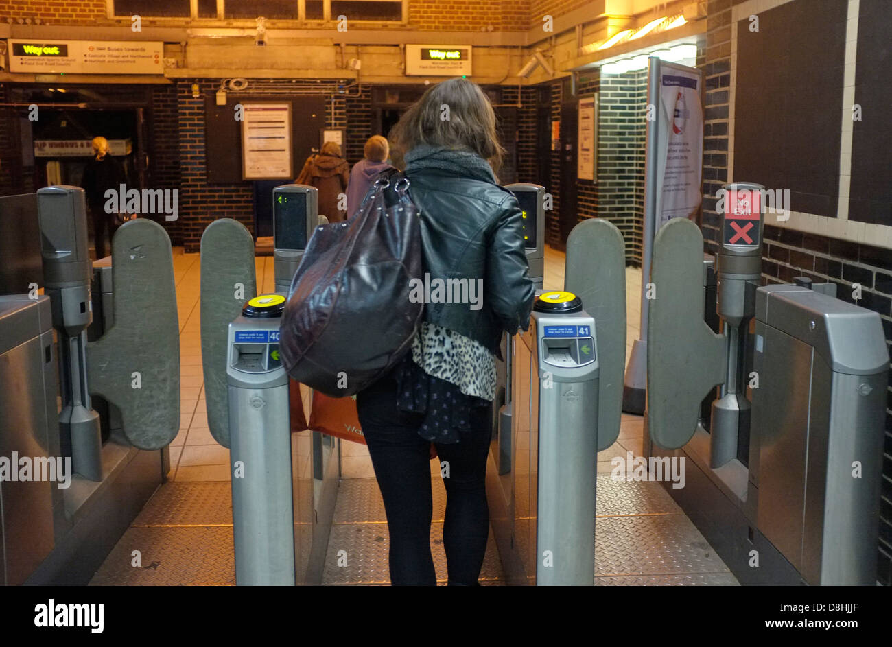 A COMMUTER PASSES THROUGH THE BARRIERS AT A TUBE STATION ON THE THE