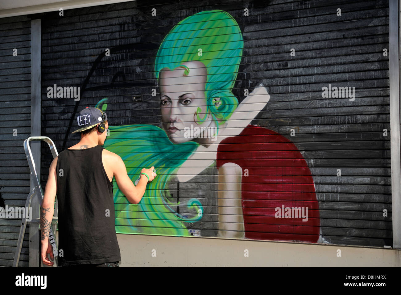 Graffiti artist Sokar Uno painting a shop shutter front at Upfest festival, Bristol, 2013, UK Stock Photo