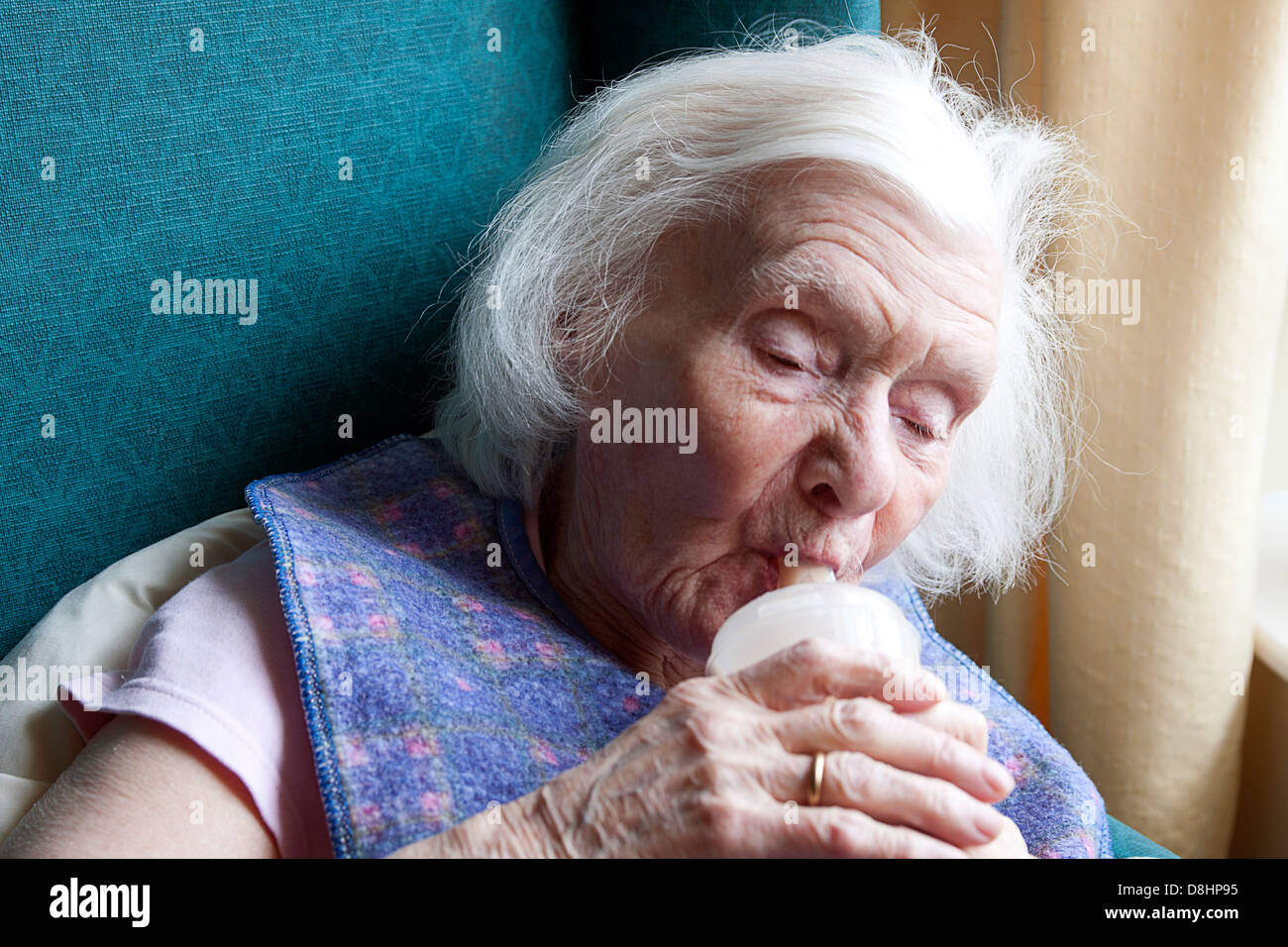 old lady with dementia drinking from beaker cup Stock Photo