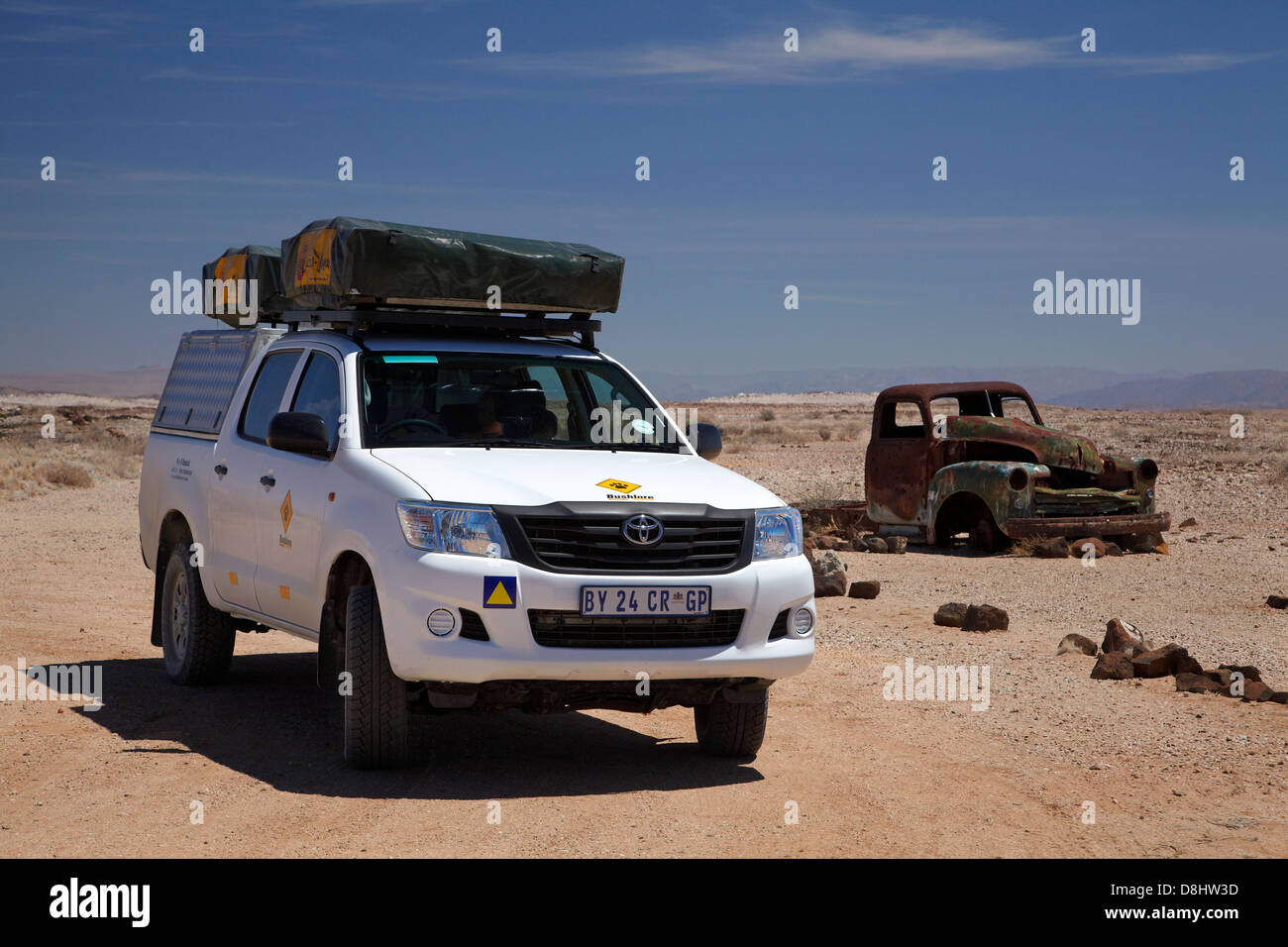 Toyota Hilux camper and derelict truck near Fish River Canyon, Southern Namibia, Africa Stock Photo