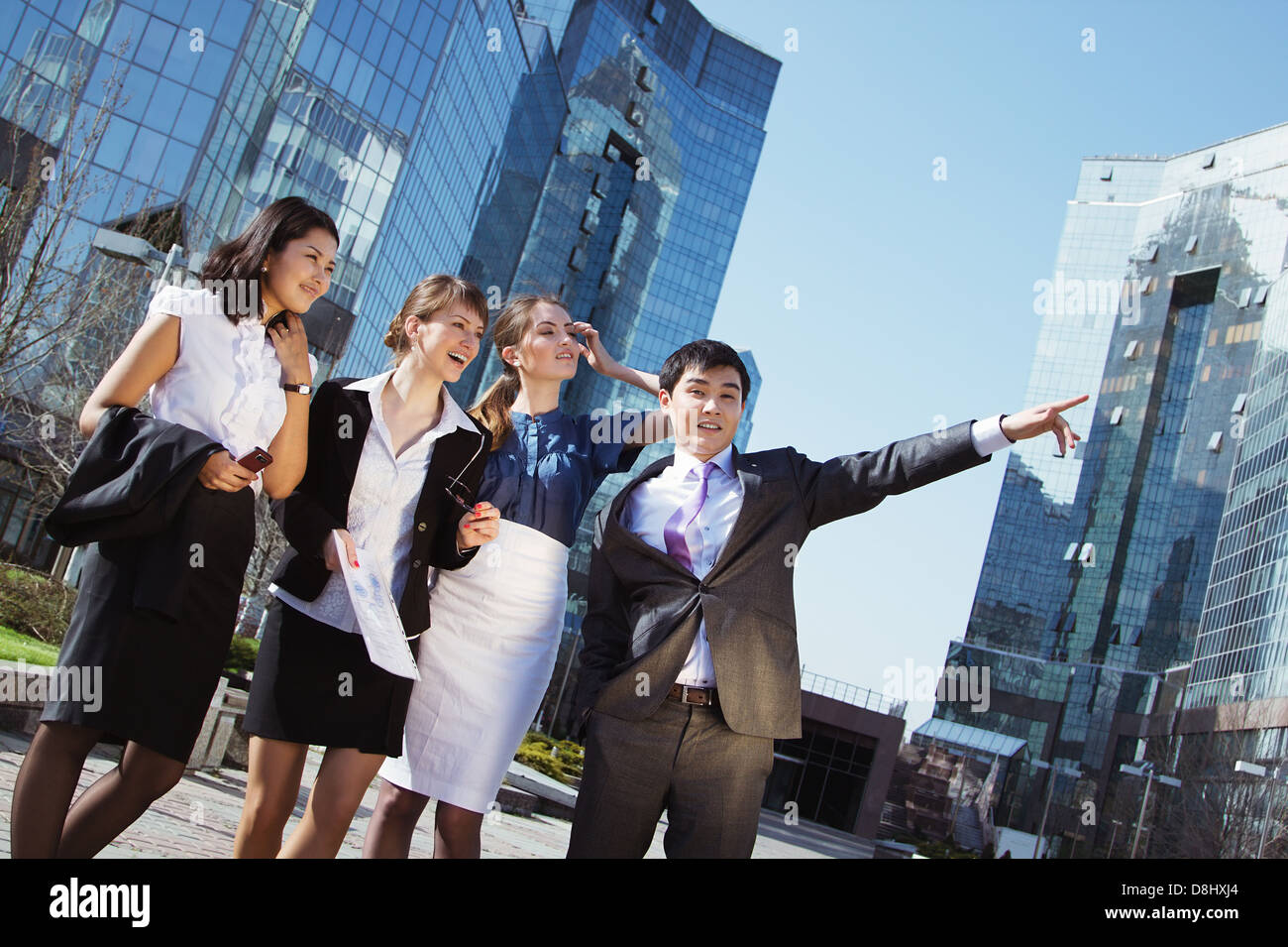 Happy diverse group of executives pointing over business center ...