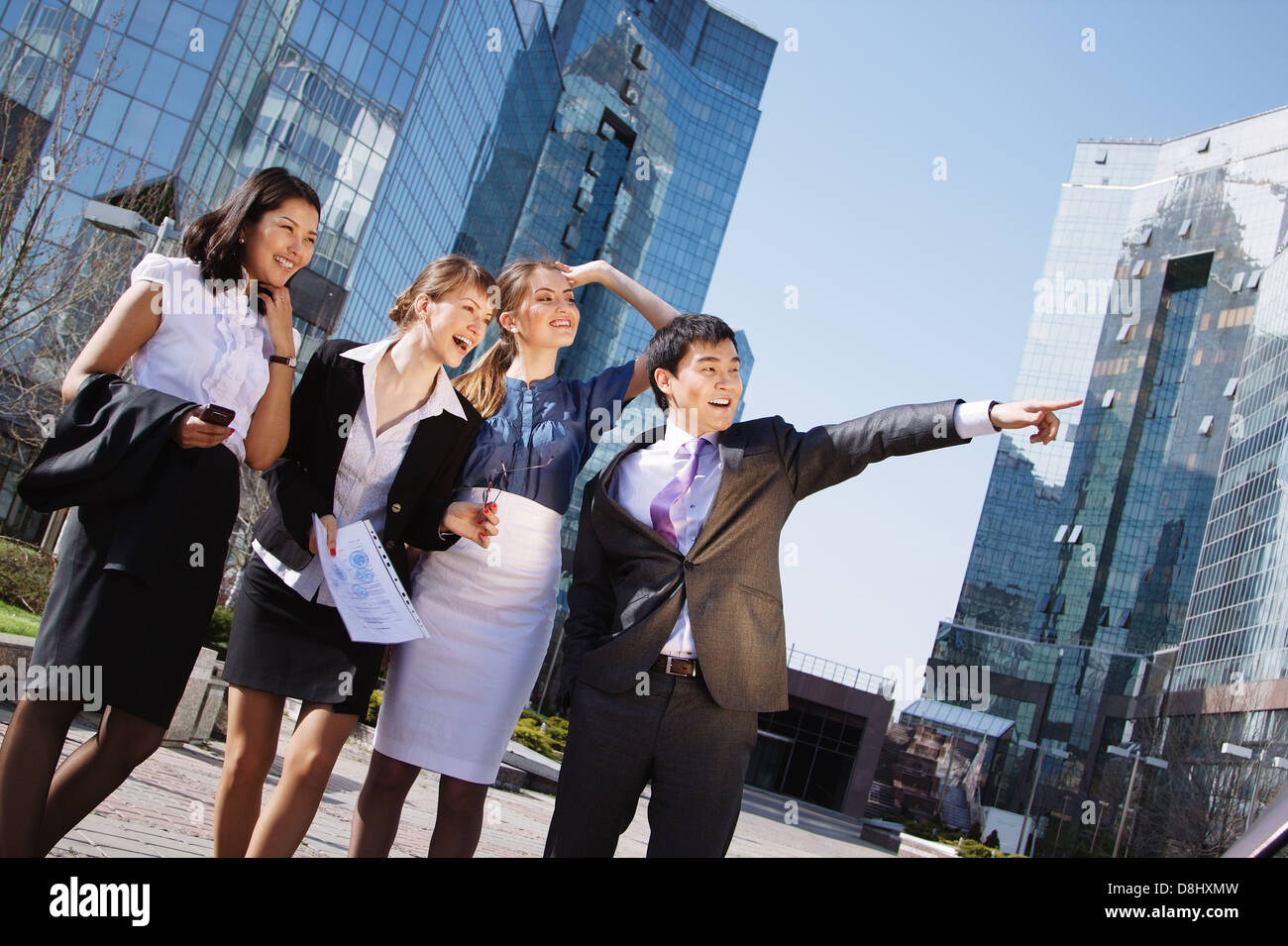 Happy diverse group of executives pointing over business center ...