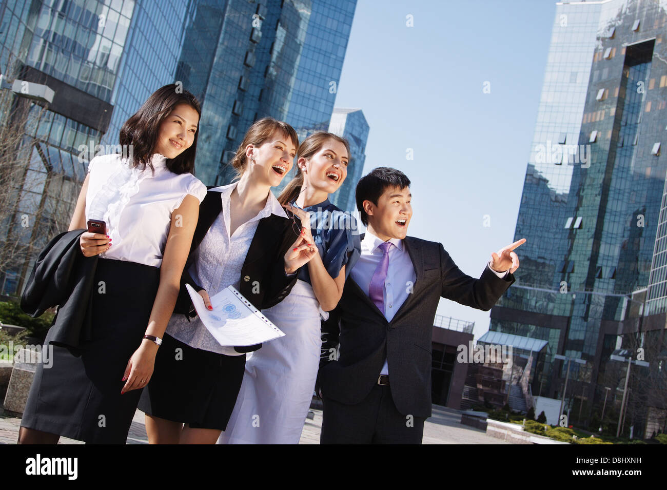 Happy diverse group of executives pointing over business center ...
