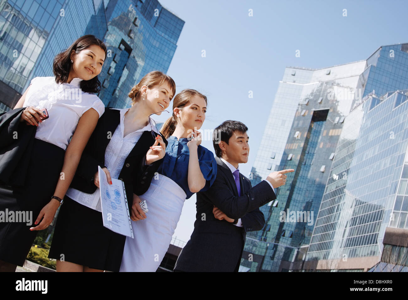 Happy diverse group of executives pointing over business center ...