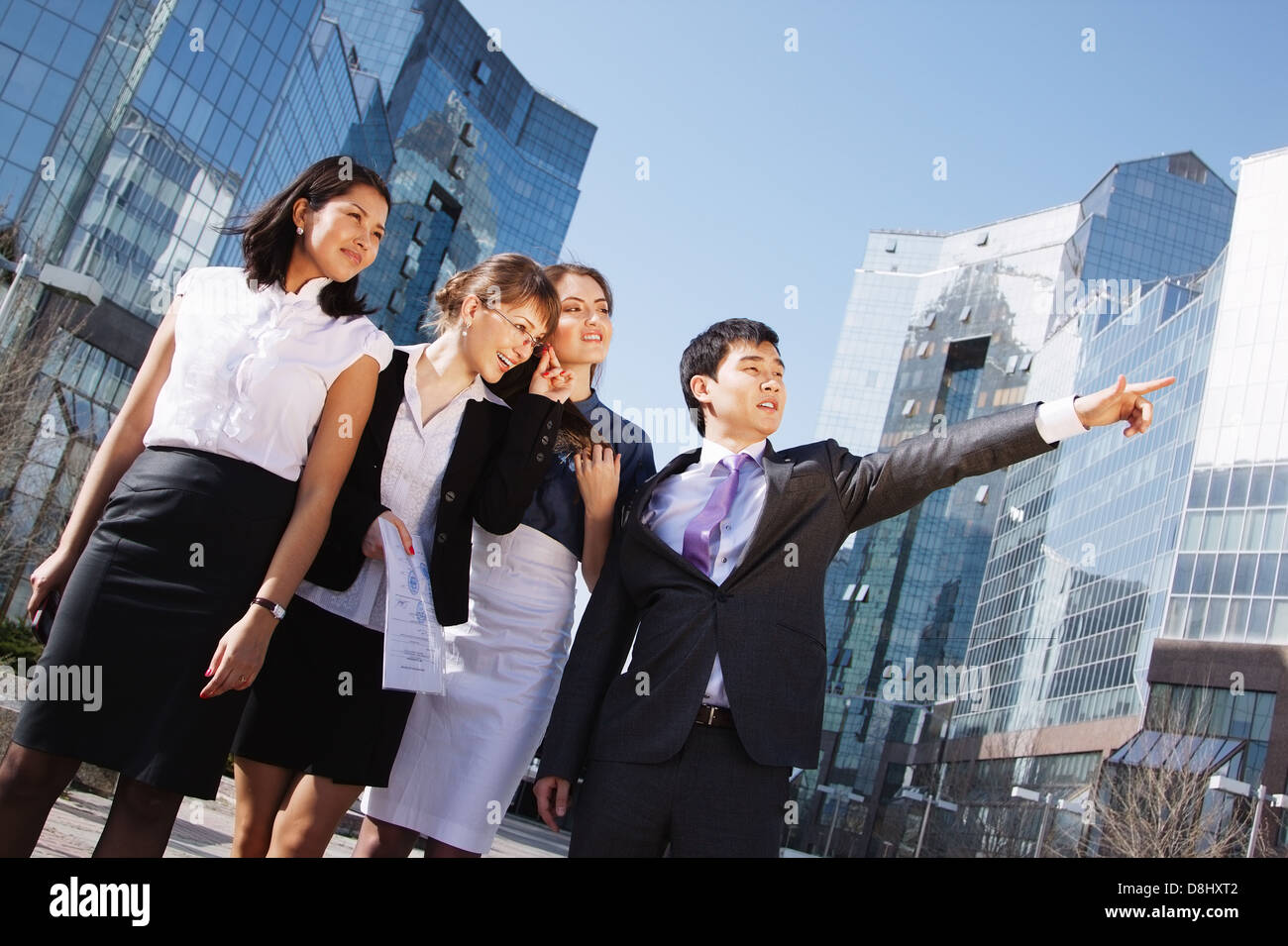 Happy diverse group of executives pointing over business center ...
