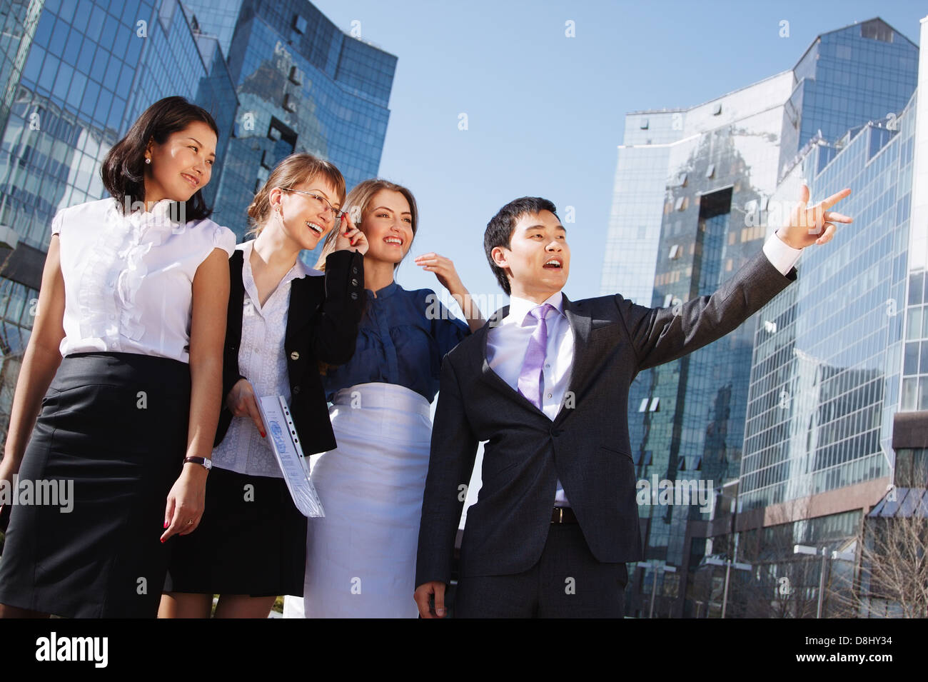 Happy diverse group of executives pointing over business center ...