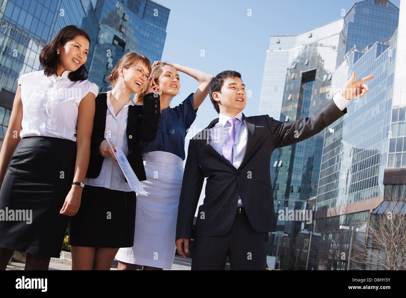 Happy diverse group of executives pointing over business center ...