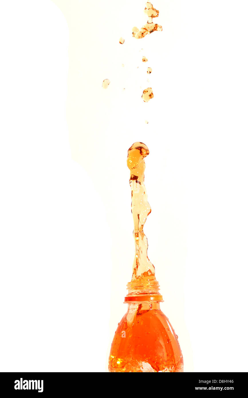 The Orange juice that spread out from the bottle on The white Background. Stock Photo