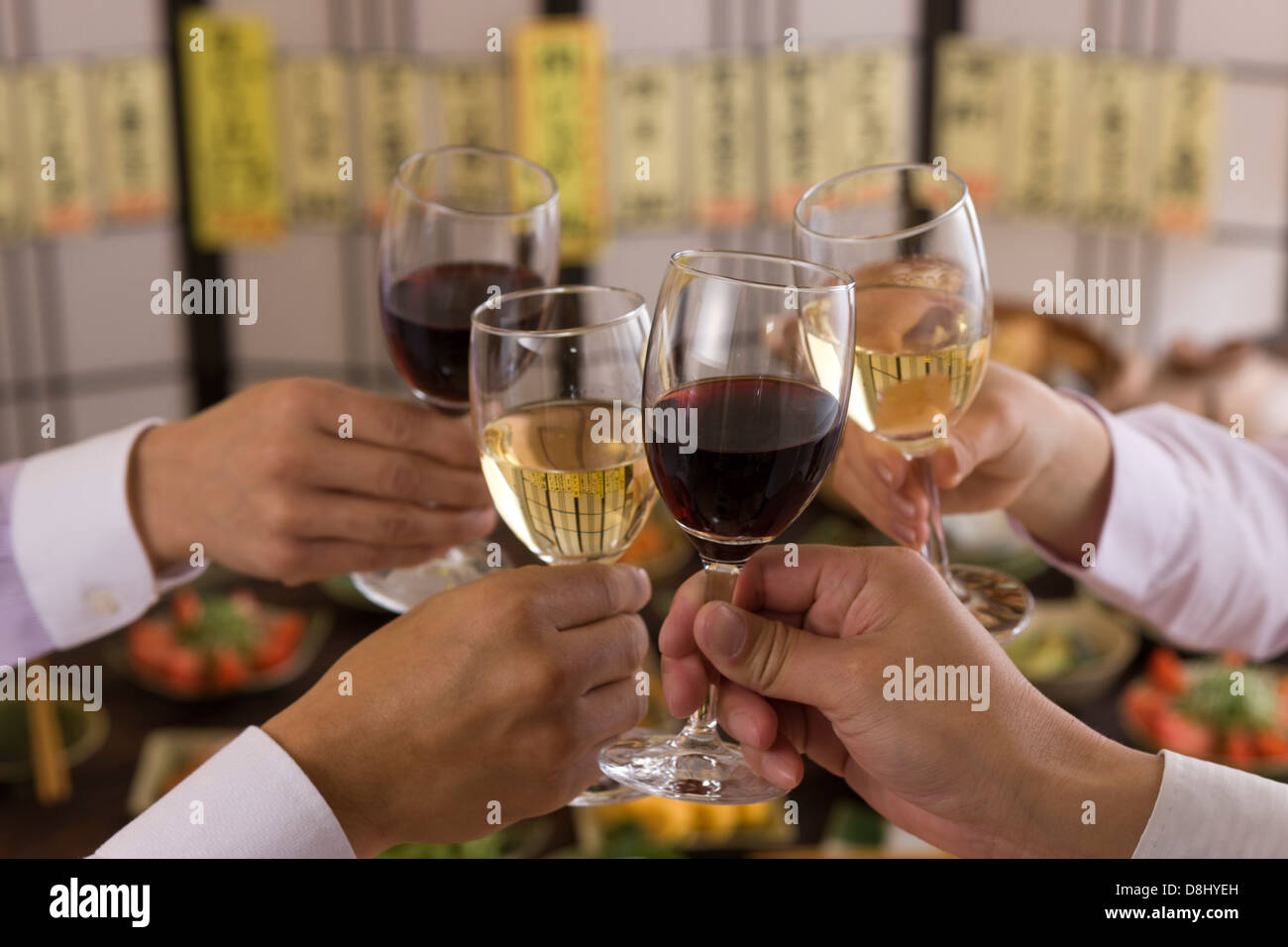 Four People Toasting with Wine at Izakaya Stock Photo