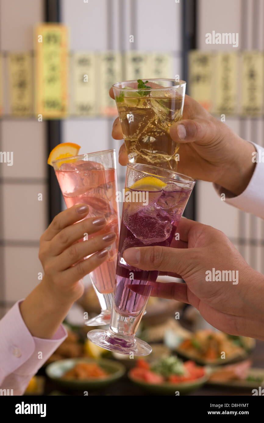 Three People Toasting with Various Cocktails at Izakaya Stock Photo
