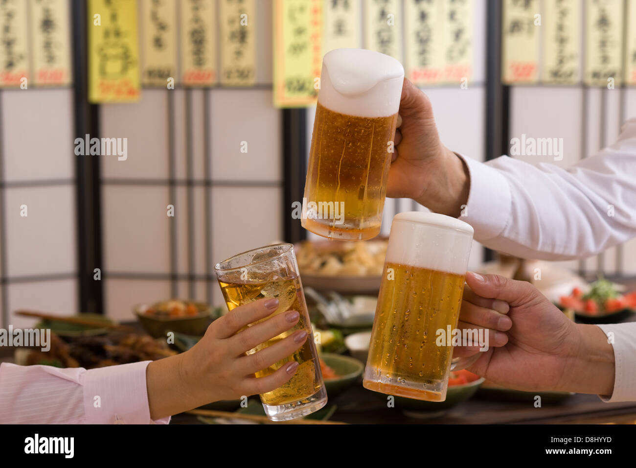 Three People Toasting with Beer and Chu-Hi at Izakaya Stock Photo