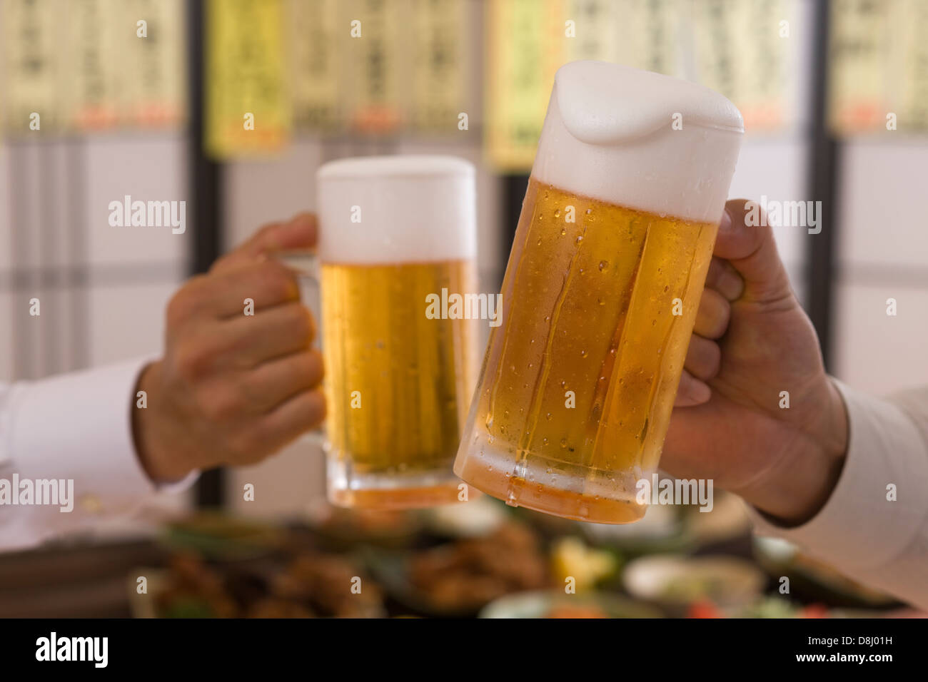 Two People Toasting with Beer at Izakaya Stock Photo