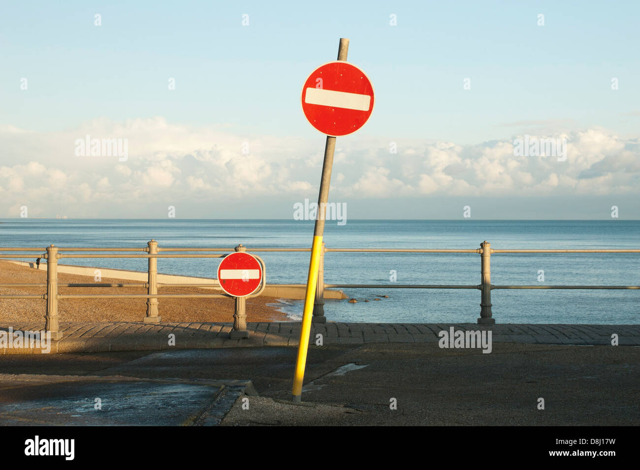 Two 'no entry' road signs at the end of the road leading into the English Channel. Stock Photo