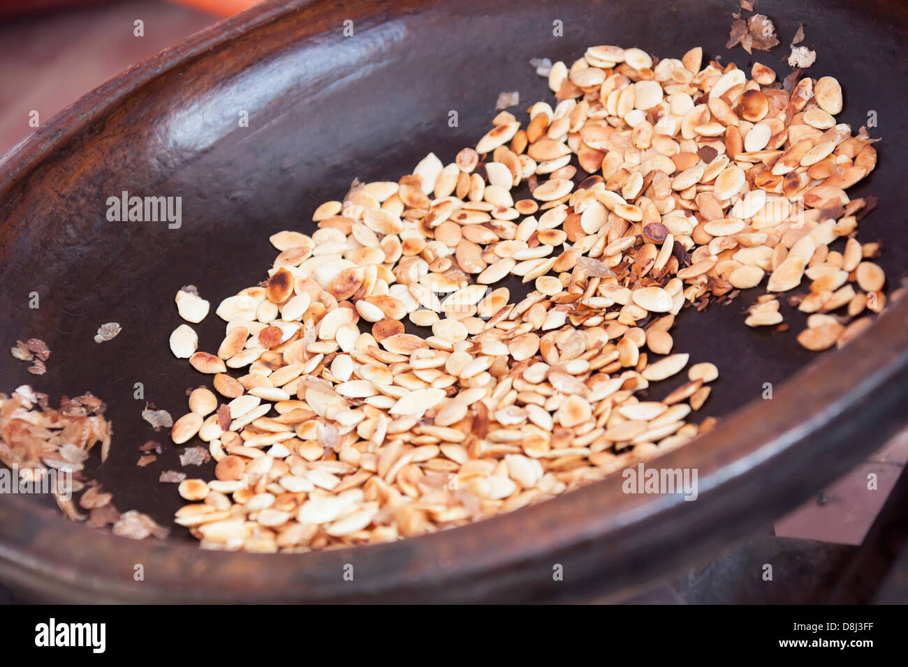 Roasted argan kernels in a frying pan. Stock Photo