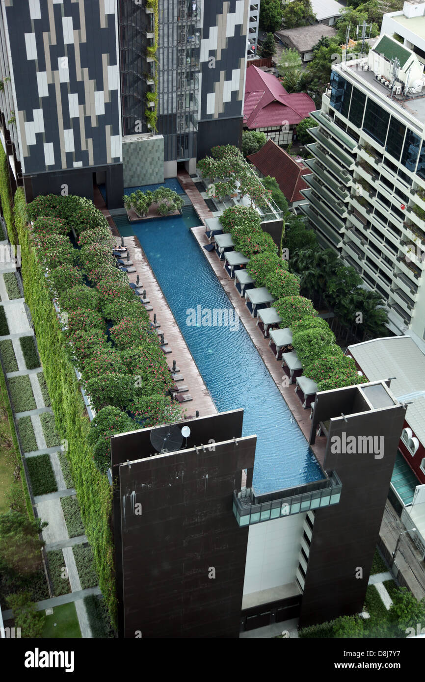 It's a photo of a swimming pool view from the sky in bangkok in Thailand. It belongs to an hotel and there are trees all along Stock Photo