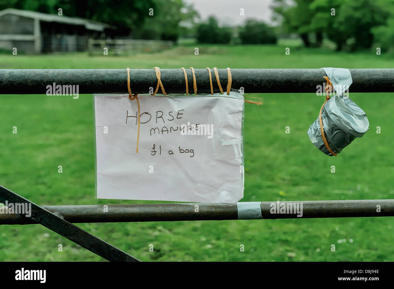Homemade sign advertising bags of manure for sale at £1 a bag in rural Yorkshire, UK. Next to the sign is an honesty box. Stock Photo