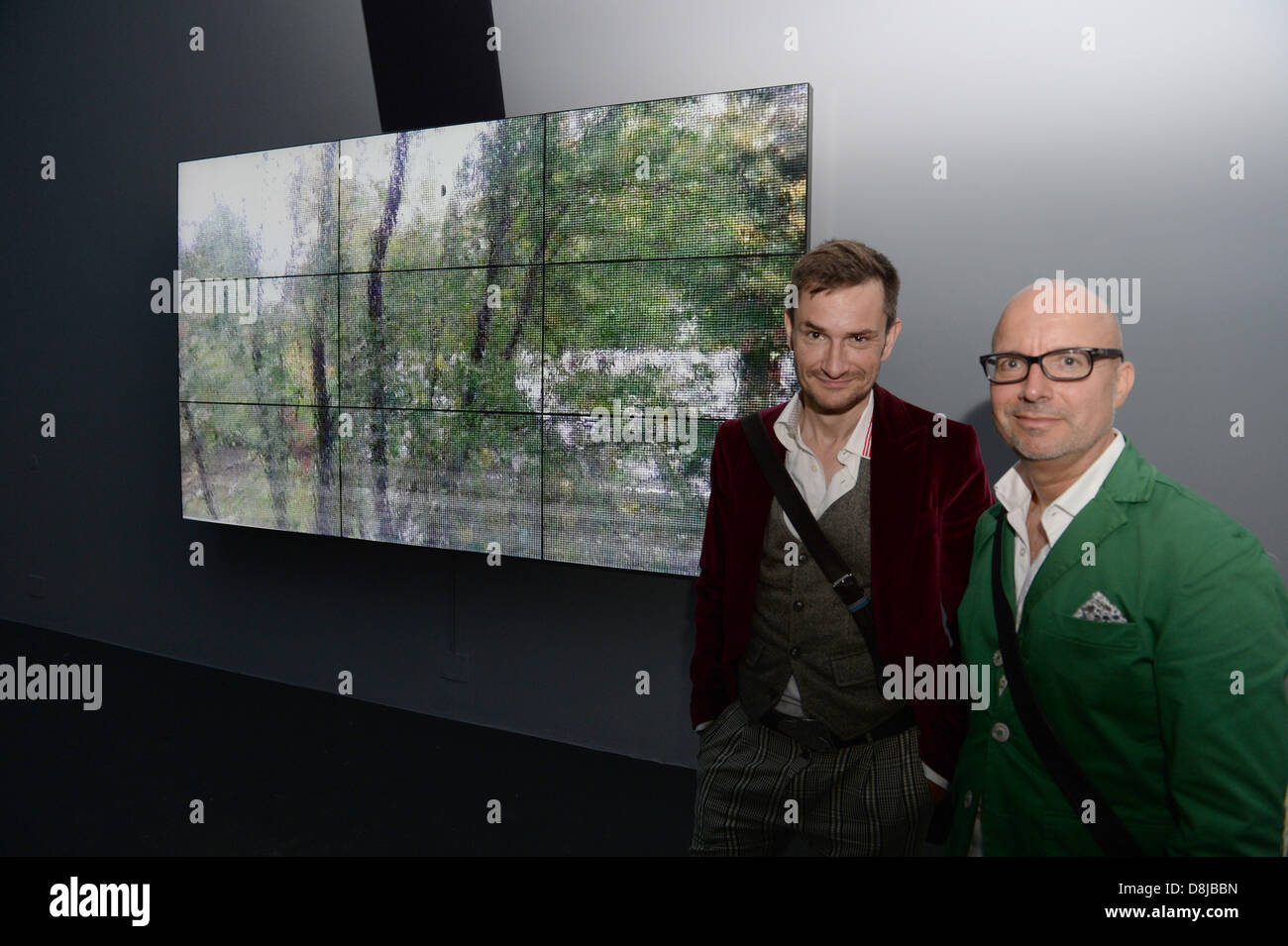 Curator of the Pinakothek of Modern Art, Bernhard Schwenk (R) and fashion designer Miro Craemer pose in front a German contribution by Romuald Karmakar titled 'Anticipation' in the French pavilion Venice, Italy, 29 May 2013. Germany and France have swapped their pavilions for this year's Venice Biennale and use them as a platform for international artists. The 55th international contemporary art exhibition, La Biennale di Venezia 2013, will be opened on 01 June. Photo: Felix Hoerhager/dpa/Alamy Live News Stock Photo