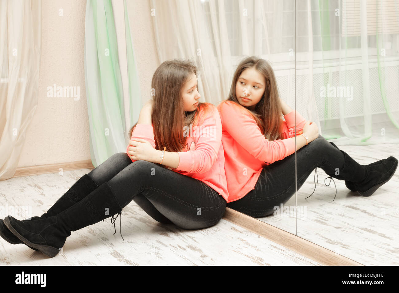 Teenage girl looking at her reflection Stock Photo - Alamy