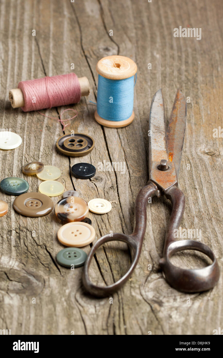 Old scissors, cottons and buttons on wooden desk Stock Photo - Alamy