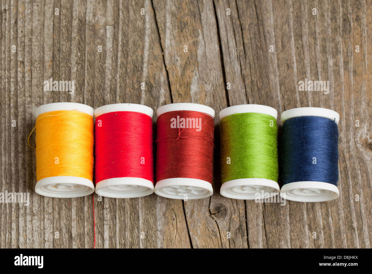 Spools of colorful threads on old wooden table Stock Photo - Alamy