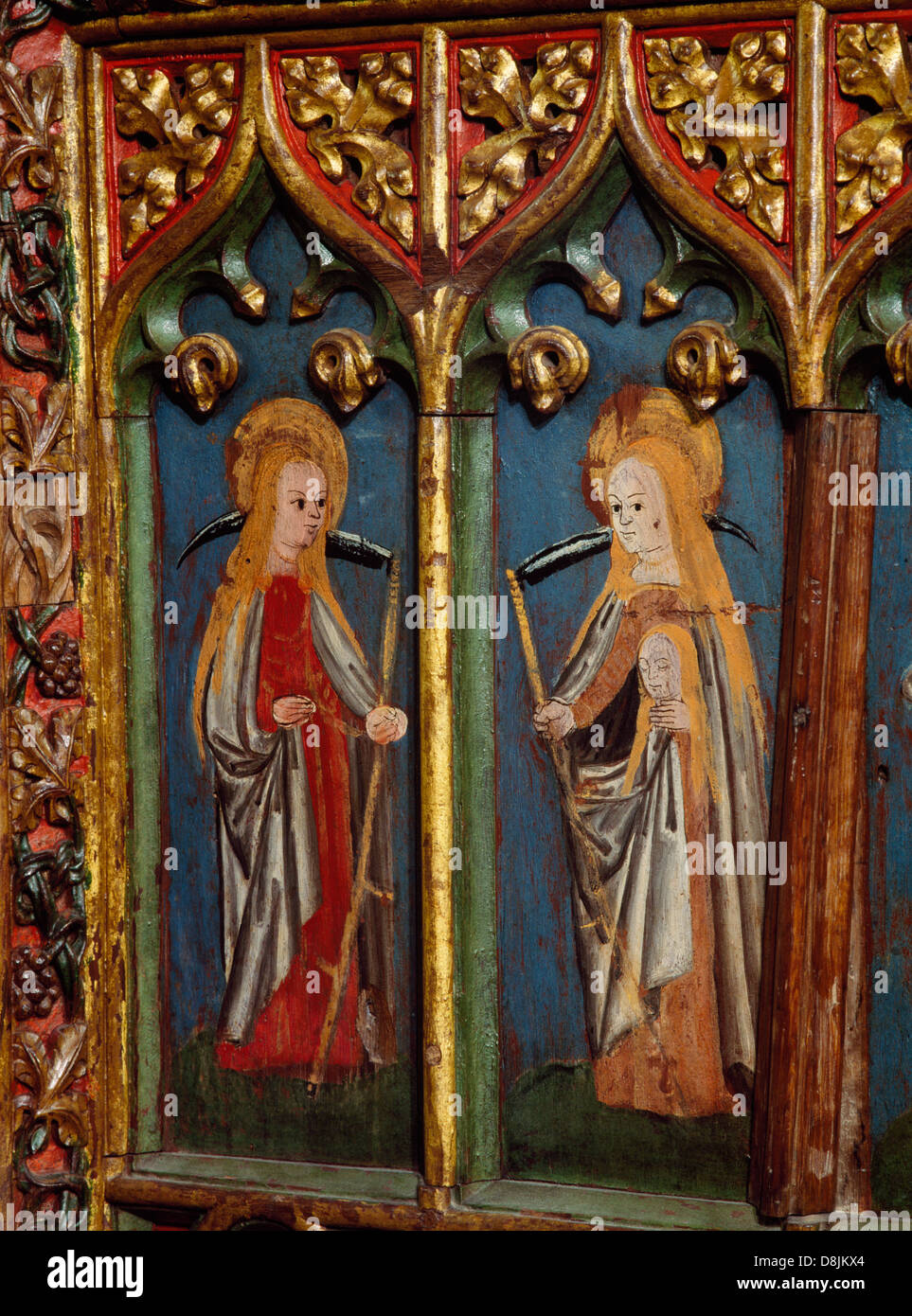 Medieval (C15th) paintings of St Urith carrying a scythe and St Sidwell with scythe and severed head on the rood screen in Hennock church, Devon. Stock Photo