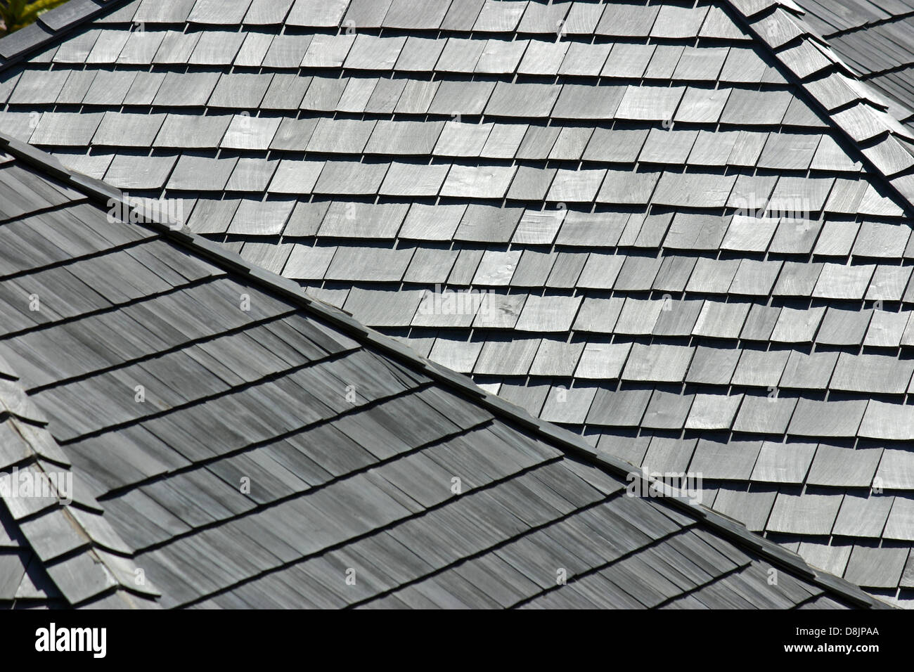Several angled rooftops with worn and weathered wooden shingles Stock Photo
