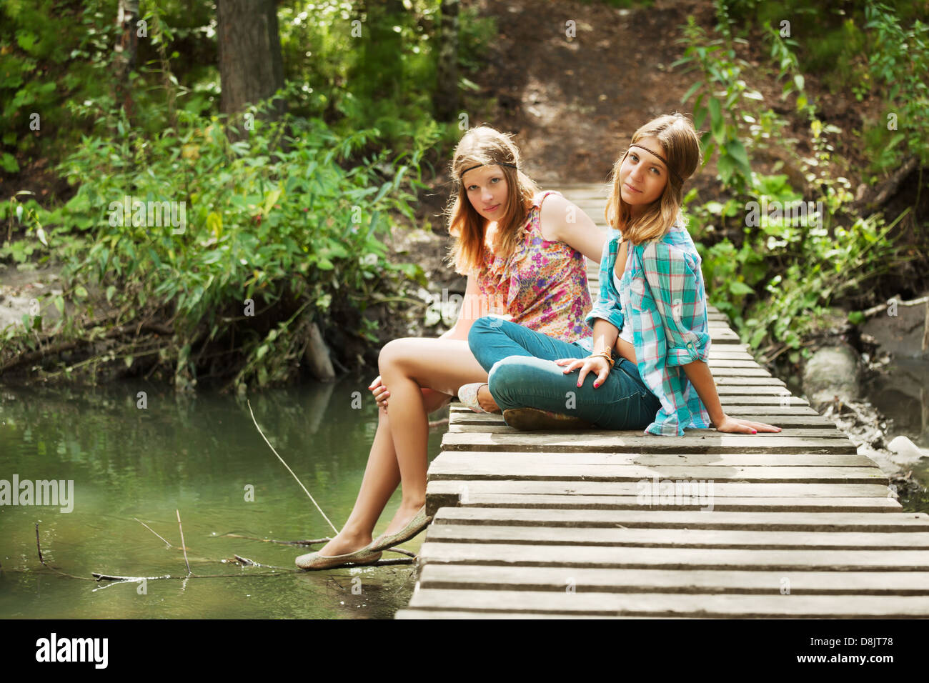 Young girls on the wooden bridge Stock Photo - Alamy
