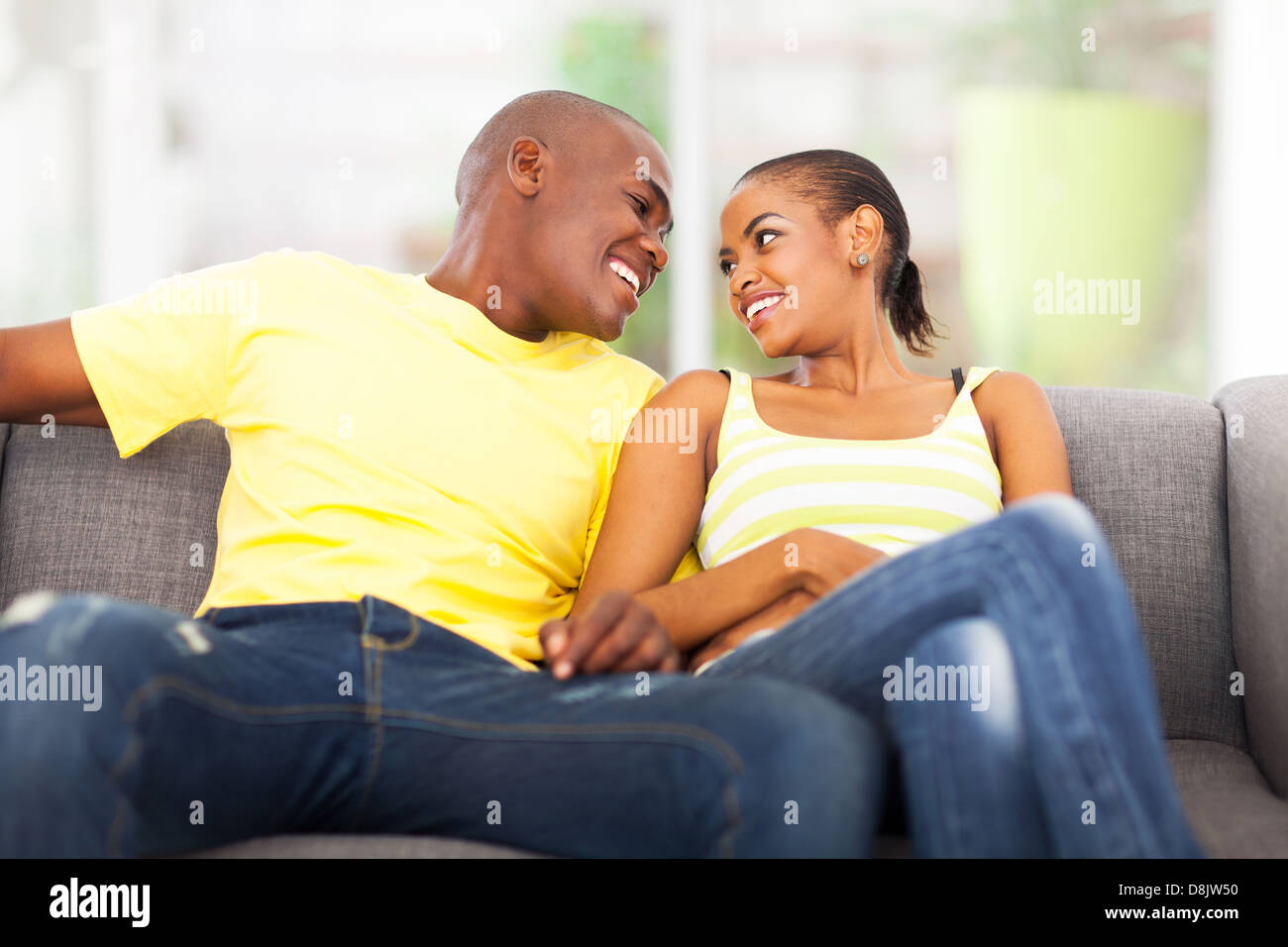 young african american couple relaxing on the couch Stock Photo - Alamy